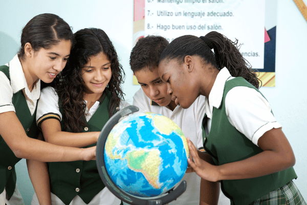 estudantes analisam globo terrestre em sala de aula