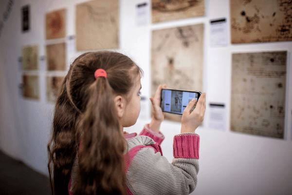 Estudante analisando exposição com inteligências artificiais do celular