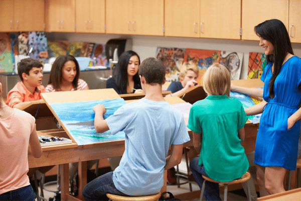 Estudantes em aula de artes pintam quadros